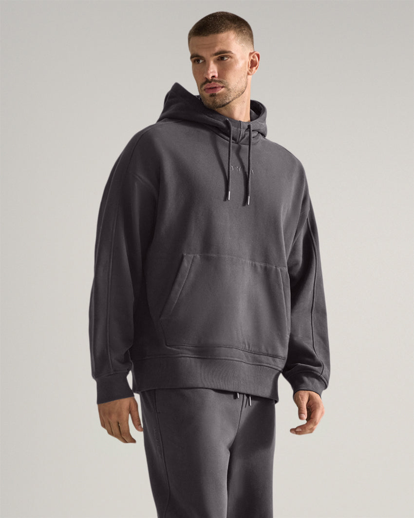 Dark-Charcoal | Three-quarter view of the Heavyweight Fleece Hoodie showing relaxed fit and kangaroo pocket