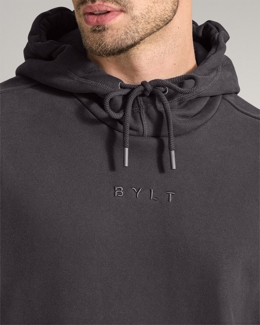 Dark-Charcoal | Close-up of the Heavyweight Fleece Hoodie hood, drawstrings and embroidered BYLT chest logo