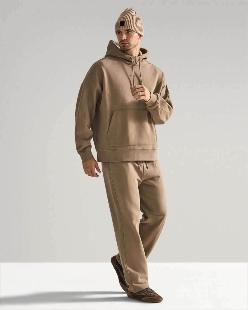 Taupe | Full-length view of the Heavyweight Fleece Hoodie worn with matching pants and a beanie while walking