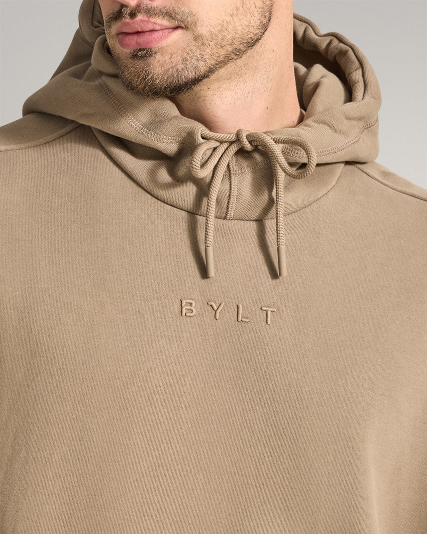 Taupe | Close-up of the Heavyweight Fleece Hoodie hood, drawstrings and embroidered BYLT chest logo